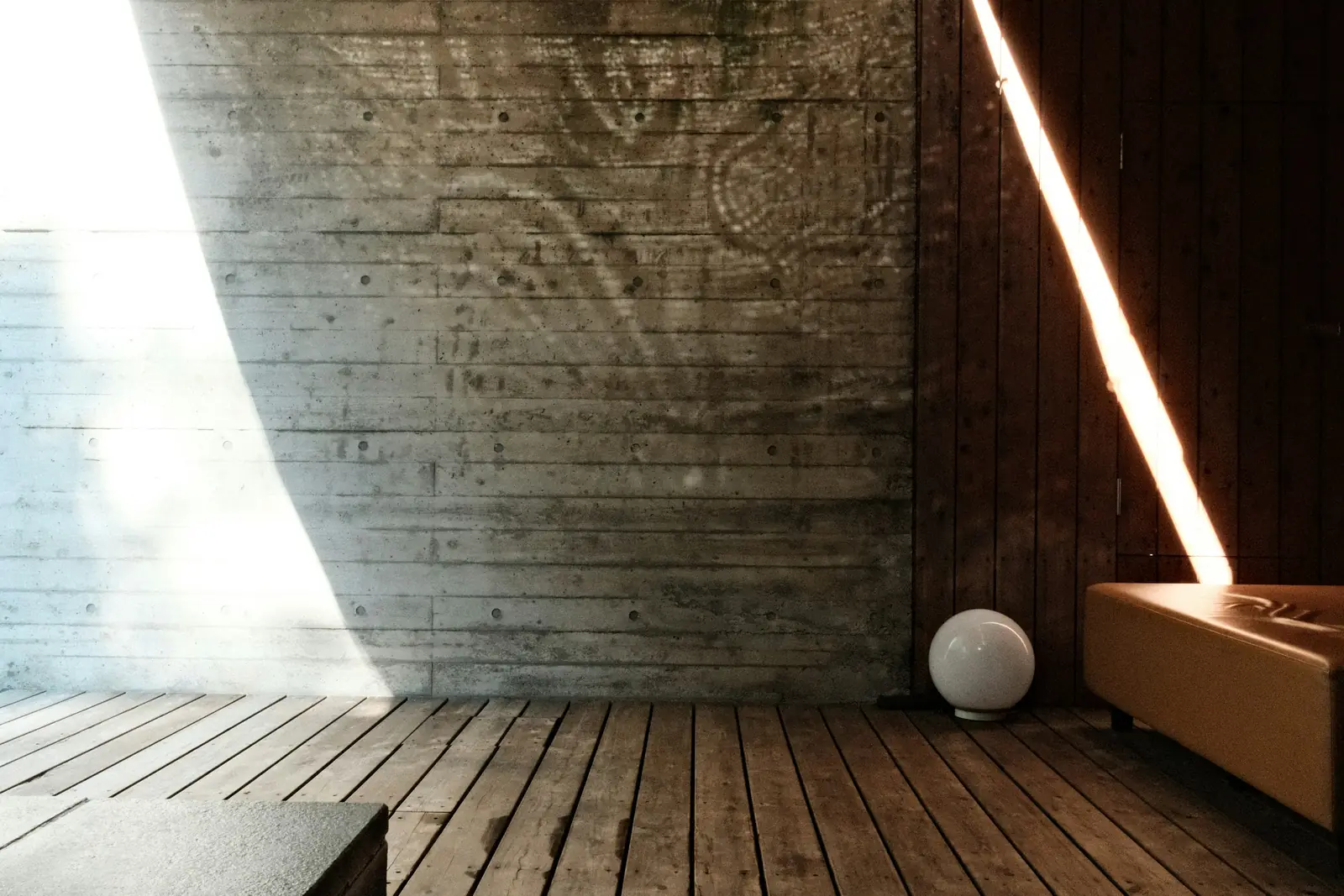 A bare room of concrete and timber, a blade of daylight across the floor.